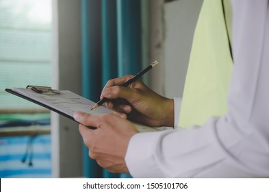 Construction. Young Foreman Builder, Engineer Or Inspector Checking And Inspecting With Clipboard At Construction Site Building Interior Before Complete New Project, Contractor And Engineering Concept