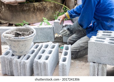 Constructor Hand Holding A Concrete Block To Build A Fence For A Country House.