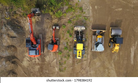 constrution machines on a construction site: excavators, bulldozer, roller compactor and wheel loader, aerial view