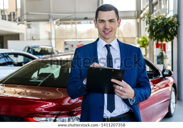 Consultant keeps
documents in background of
cars