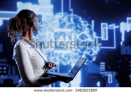 IT consultant uses laptop to develop artificial intelligence neural networks nodes modeled after human brain. Server room worker setting up AI machine learning accurately making predictions using data