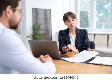 Consultant working with client at table in office. Business meeting