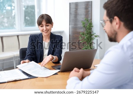 Consultant working with client at table in office. Business meeting