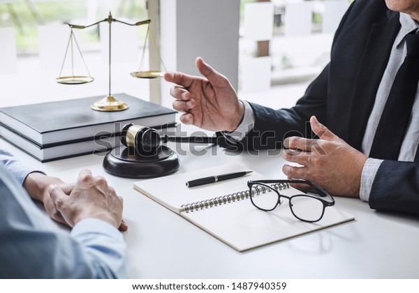 Consultation and\
conference of Male lawyers and professional businesswoman working\
and discussion having at law firm in office. Concepts of law, Judge\
gavel with scales of\
justice.