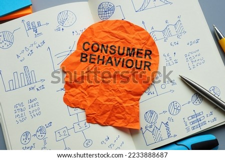 Consumer behaviour sign on the paper head and open notepad with marks.