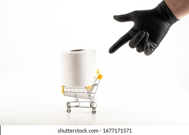 Consumer Buying Panic About Coronavirus Covid-19 Concept. Toilet Paper Roll In Shopping Trolley.A Black Gloved Hand Is Showing Trolley For Hygiene.People Are Stocking Up Essentials For Home Quarantine