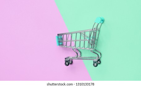 Consumer concept, mini shopping trolley for shopping on a colored background, minimalism, top view.