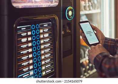 Consumer paying for product at vending machine using contactless method of payment with mobile phone. Man using payment app on smartphone to buy product. Male hand holding smart phone with payment app - Shutterstock ID 2154165079