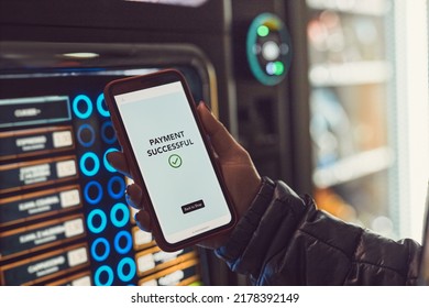 Consumer paying for product at vending machine using contactless method of payment with mobile phone. Woman using payment app on smartphone to buy product. Female hand holding smart phone with pay app