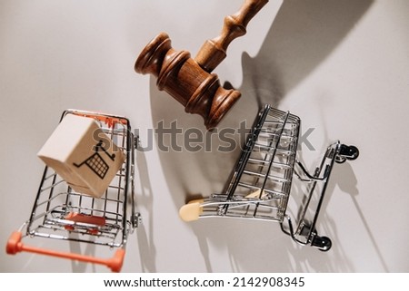 Consumer rights concept, judge gavel and grocery carts on a table. Top view
