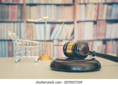 Consumer rights and protection, business law concept : Wooden judge gavel, a shopping cart, a balanced scale of justice on a table, depicting the practice of safeguarding buyers of goods and services.