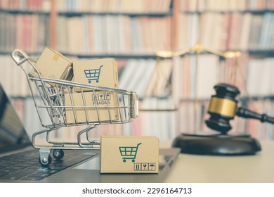 Consumer rights and consumer protection, business law concept : Shopping basket, shopping boxes and a shopping cart on a laptop computer with judge gavel, balance sale of justice and bookshelf behind.