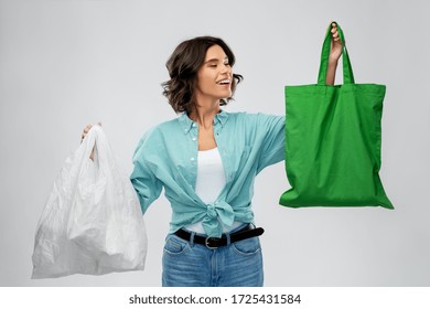 consumerism, sustainability and eco living concept - portrait of happy smiling young woman in turquoise shirt and jeans with plastic and green reusable canvas bag for food shopping on grey background - Powered by Shutterstock