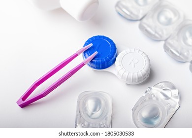 Contact Lens Kit With Lenses, Bottle Of Lens Solution, Case, Tweezers On White Table, Top View