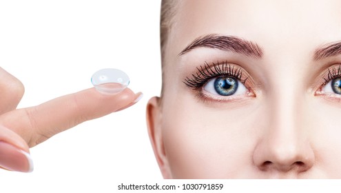 Contact lens on index finger near beautiful female face.