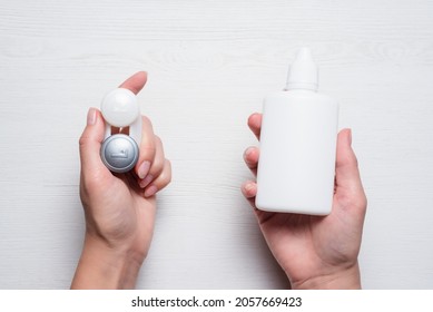 Contact Lenses And Bottle With Eye Solution In Female Hands Concept.