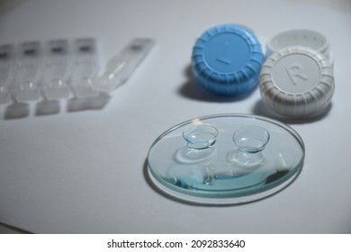 Contact Lenses On The Magnifyng Glass.Artificial Tear ,eye Drops And Contact Lens Case.Contact Lenses Have Practic Than Glasses