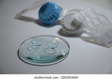 Contact Lenses On The Magnifyng Glass.Artificial Tear ,eye Drops And Contact Lens Case.Contact Lenses Have Practic Than Glasses