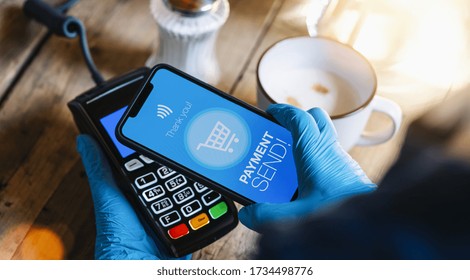 Contact Less Payment On A Mobile Phone. Close Up Of A Woman Hand With Gloves Paying Contactless With A Smartphone Screen Application. Hand Holding Smart Device To Pay. Mockup Cellphone Screen.