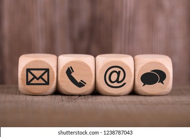 Kontaktmethoden. Nahaufnahme eines Handys, E-Mail, Chat und Post-Symbole aus Holzblock.