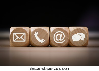 Contact Methods. Close-up of a phone, email, chat and post icons wooden block.