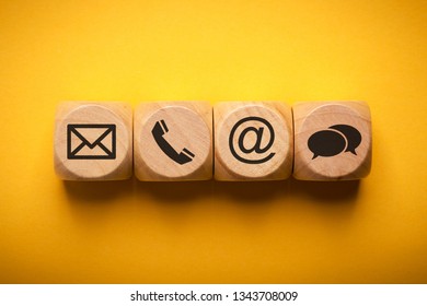 Contact Methods. Close-up of a phone, email, chat and post icons wooden block.