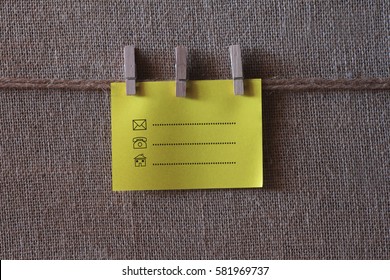 Contact symbol written on a wooden table and paper sticky notes.
