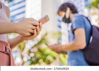 Kontakt-Rückverfolgungs-App COVID-19 Pandemic Coronavirus Mobile Application - Menschen, die Gesichtsmaske tragen, mithilfe der Smartphone-App in der City Street, um die Kontaktaufspürung als Reaktion auf den Coronavirus 2019-20 zu unterstützen
