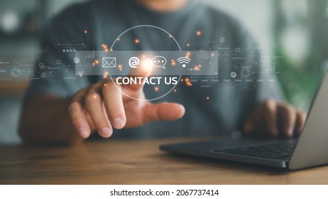 Contact us or Customer support hotline people connect. Businessman using a laptop and touching on virtual screen contact icons ( email, address, live chat, internet wifi ). - Shutterstock ID 2067737414