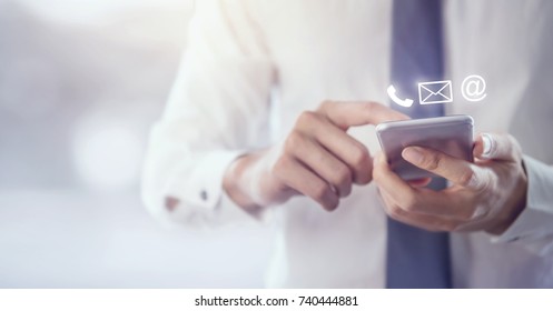 CONTACT US, Hand of Businessman holding mobile smartphone with ( mail,phone,email ) icon. cutomer support concept, copy space. - Shutterstock ID 740444881
