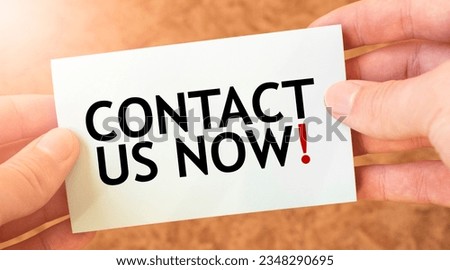 CONTACT US NOW word inscription on white card paper sheet in hands of a businessman. recap concept. red and white paper