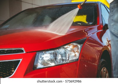 Contactless car wash self-service. Young man washing his car