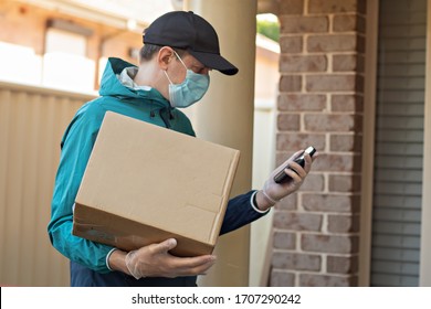 Contactless delivery during COVID-19 pandemic lockdown concept. Courier wearing mask and gloves holds a parcel box and checking address details on the smartphone - Shutterstock ID 1707290242