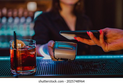 Unberührte mobile Zahlung. Zahlungsterminal und Smartphone in der Bar