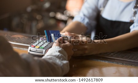 Contactless payment concept, female customer holding credit card near nfc technology on counter, client make transaction pay bill on terminal rfid cashier machine in restaurant store, close up view Сток-фото © 