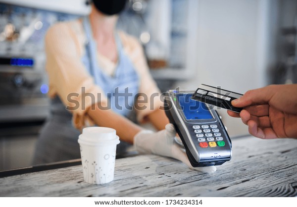 Contactless payment with debit card, coffee\
shop open after\
lockdown.