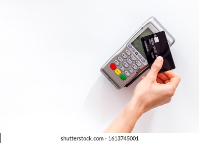 Contactless payment, paypass. Hand hold bank card near terminal on white background top-down copy space