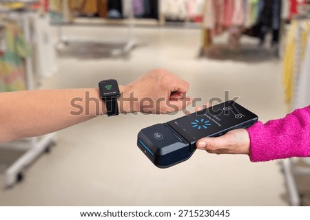 Contactless payment using smart watch and mobile POS terminal inside retail store, showing wearable payment technology, modern checkout experience, and cashless shopping concept