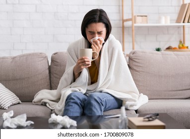 Contagious disease outbreak. Sick girl with hot drink suffering from virus at home