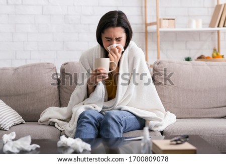 Contagious disease outbreak. Sick girl with hot drink suffering from virus at home