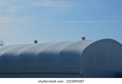 container building permanently forms a warehouse with offices. covered with a rubber sheet on a tent structure. ventilation with the help of a stainless steel propeller chimney. round, hangar