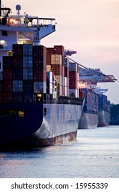 Container Cargo Ships Docked In Port - Three Huge Freighters At Harbor Terminal During Sunset