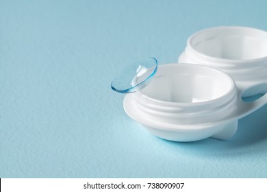 Container for contact lenses, contact lenses on blue background. Close-up