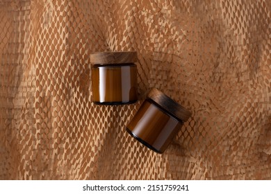 Container for cosmetics and creams. Glass brown jar with wooden lid. Beige background. Monochrome concept. Place for a label. Cream jars. Beauty and care. Minimalism