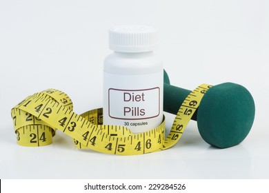 Container of diet pills with yellow tape measure and weight.