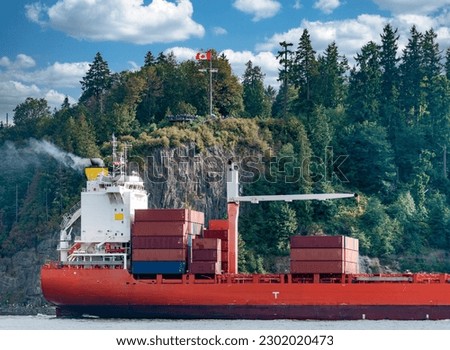 Container freight vessel is passing by Stanley Park in Vancouver harbor