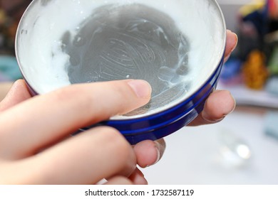 A container with leftover skin cream in a woman's hand. Finishing skin cream. Close up. - Shutterstock ID 1732587119
