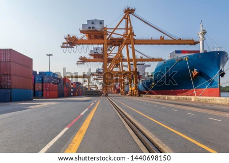 Container loading in a cargo freight ship with crane to shore lift up loading export containers box in import and export business logistic industry and transportation concept.