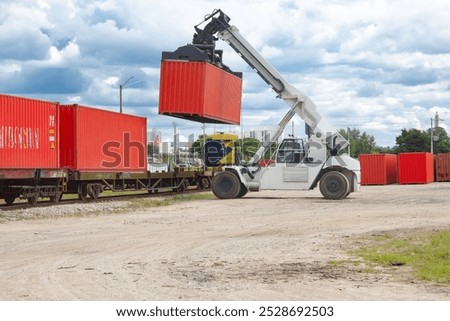 container magnetic forklift loading freight train stopped in warehouse