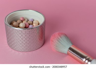 container of pretty face powder pearls in pink and purple colours with copy space 